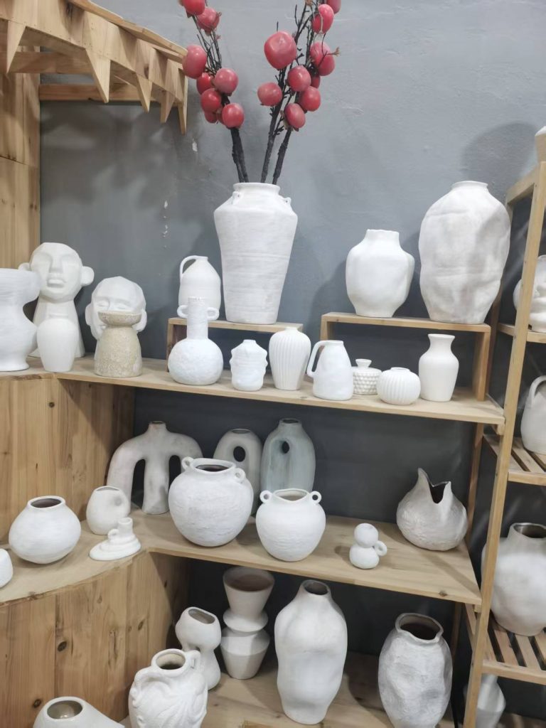 Elegant porcelain vases displayed on a wooden shelf by a trusted porcelain vase supplier